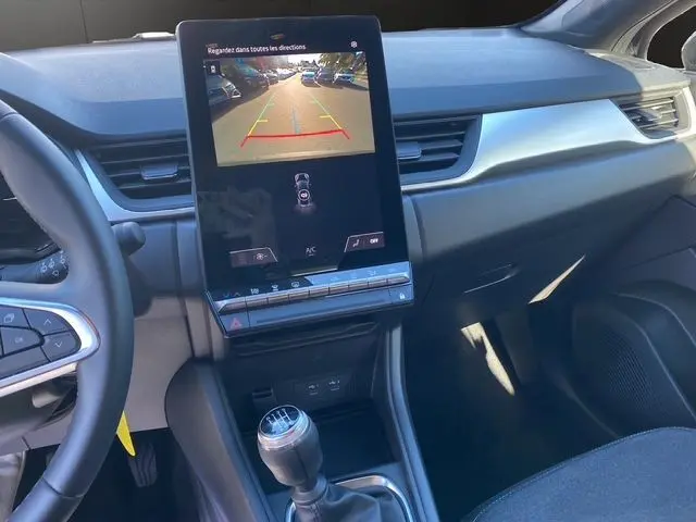 Intérieur avant du Renault Captur noir 2024 montrant la console centrale avec écran tactile et levier de vitesse manuel.