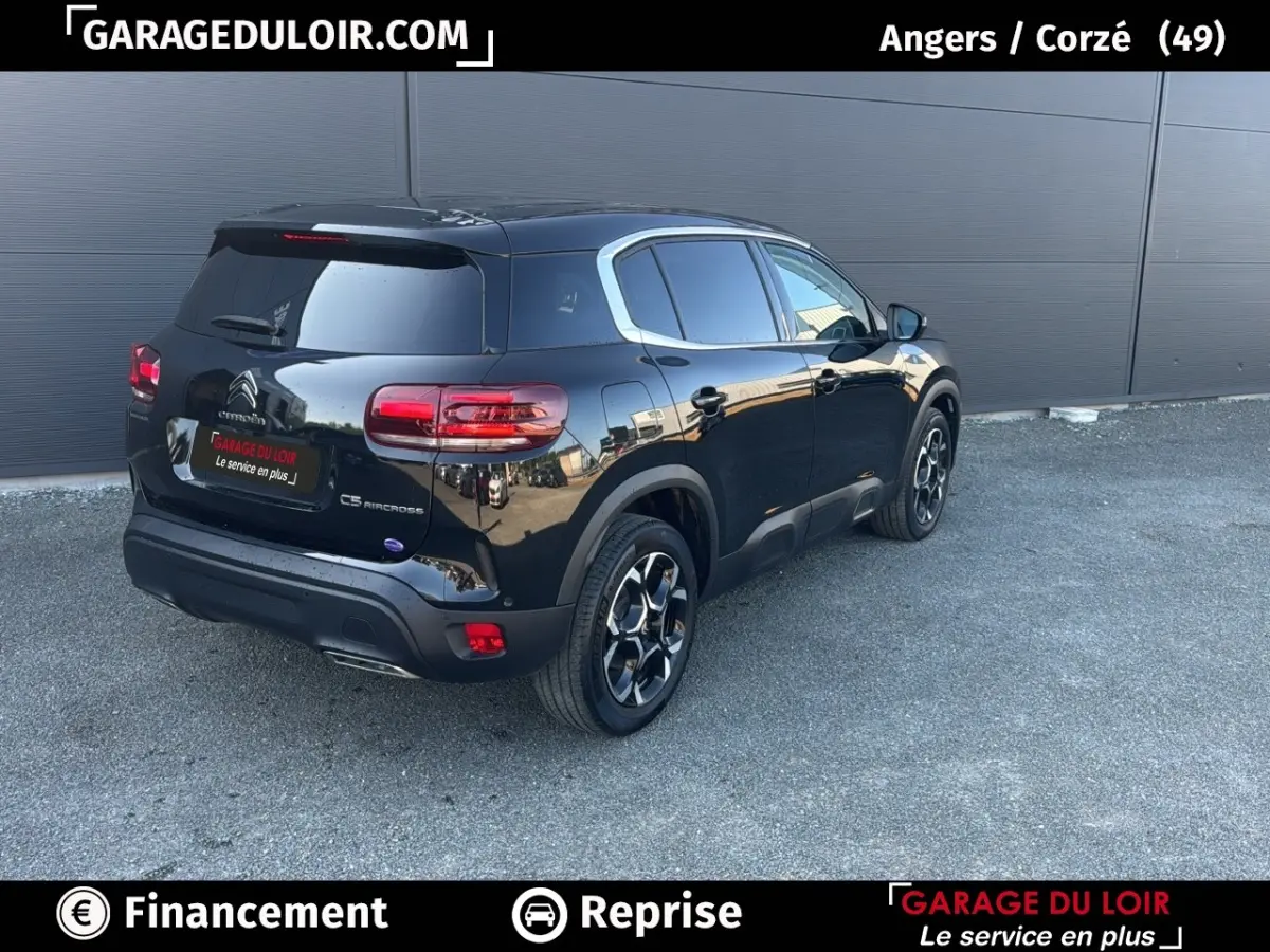 Vue 3/4 arrière droite d'un Citroën C5 Aircross noir 2025 avec jantes distinctives et vitres teintées.