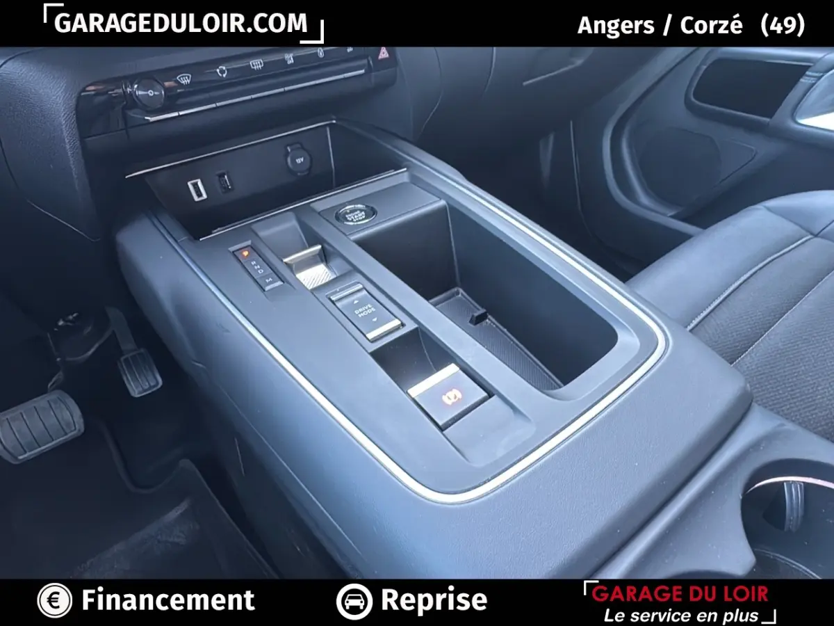 Vue rapprochée de la console centrale noire du Citroën C5 Aircross 2025 avec commandes électroniques et rangements.