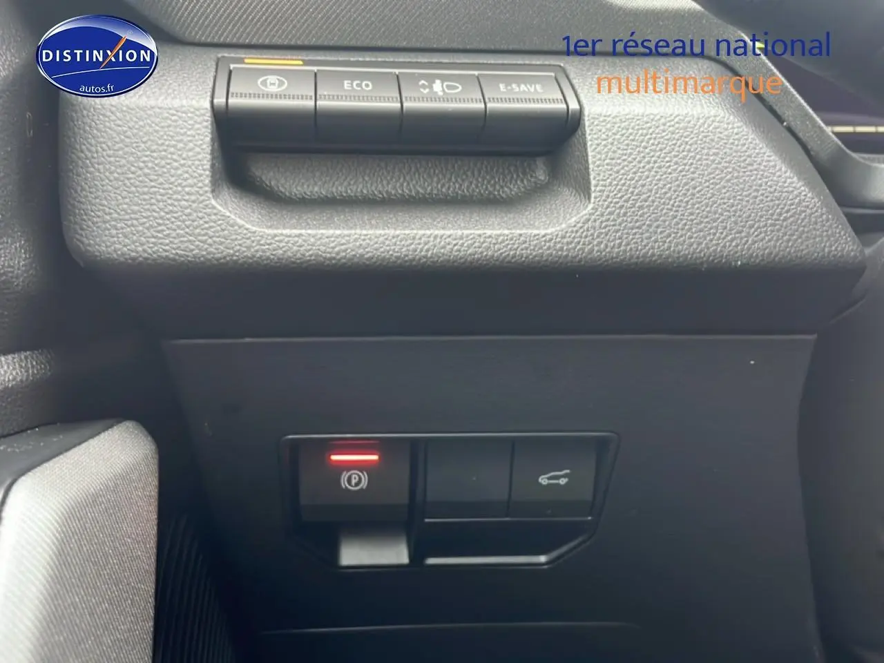 Gros plan sur les commandes de la planche de bord du Dacia Bigster noir, avec bouton frein à main électronique allumé.