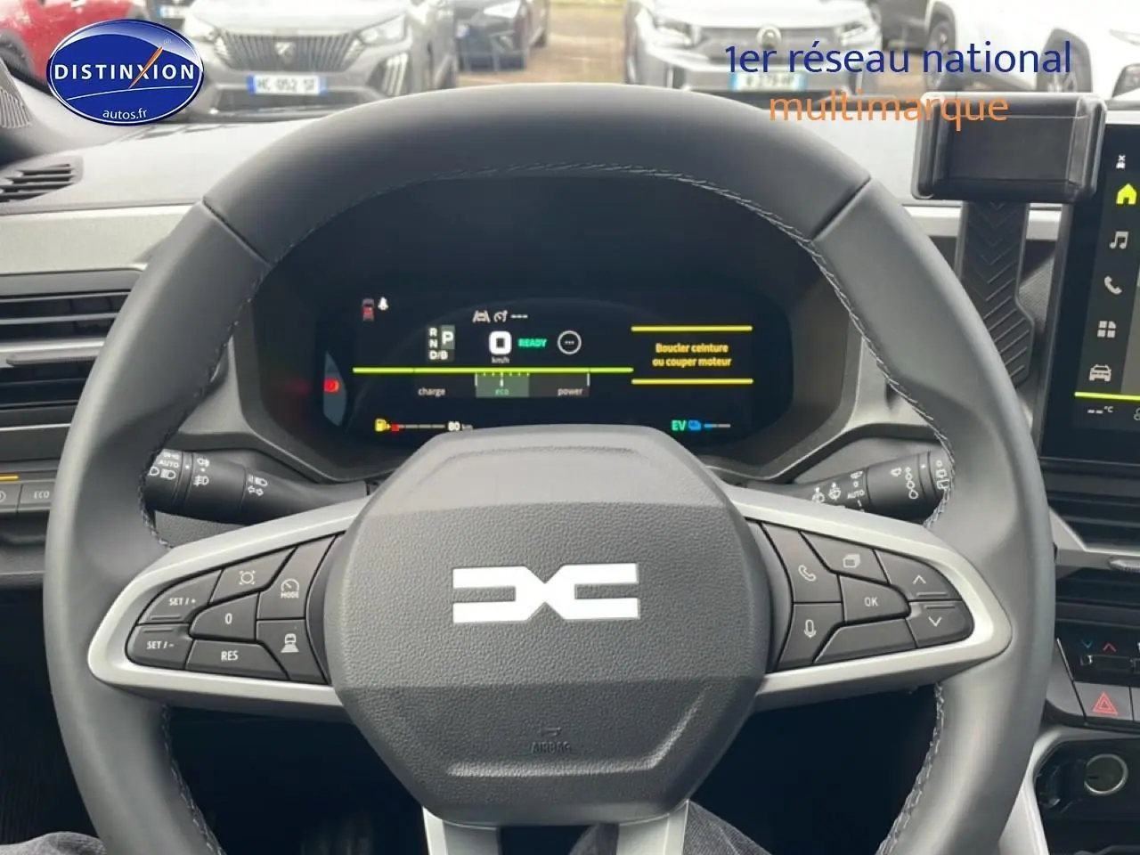 Vue intérieure centrée sur le volant cuir noir du Dacia Bigster 2025 avec tableau de bord numérique allumé.