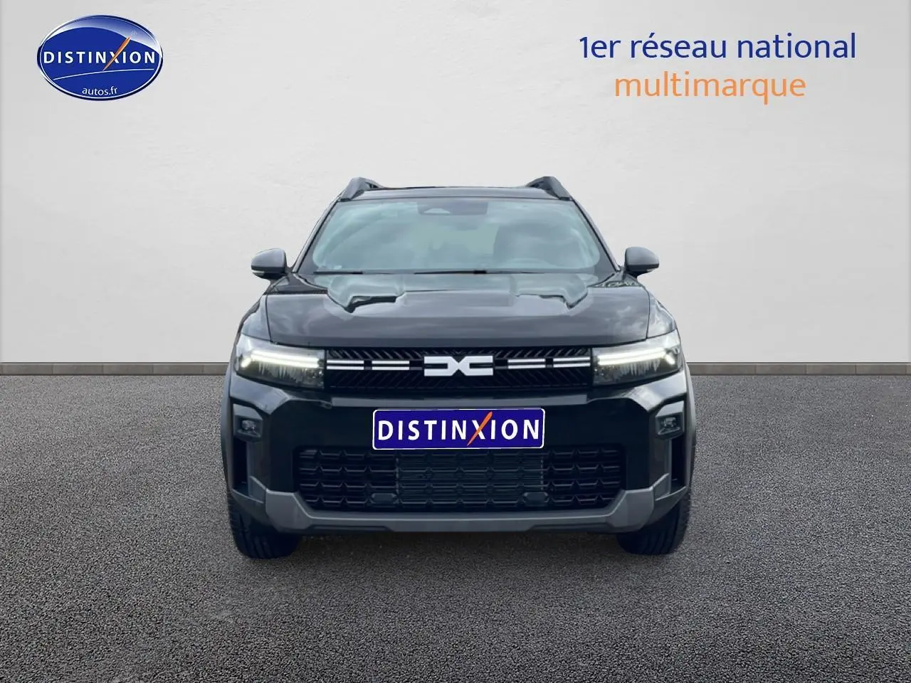 Vue avant d’un Dacia Bigster noir 2025 avec calandre distinctive et phares LED allumés.