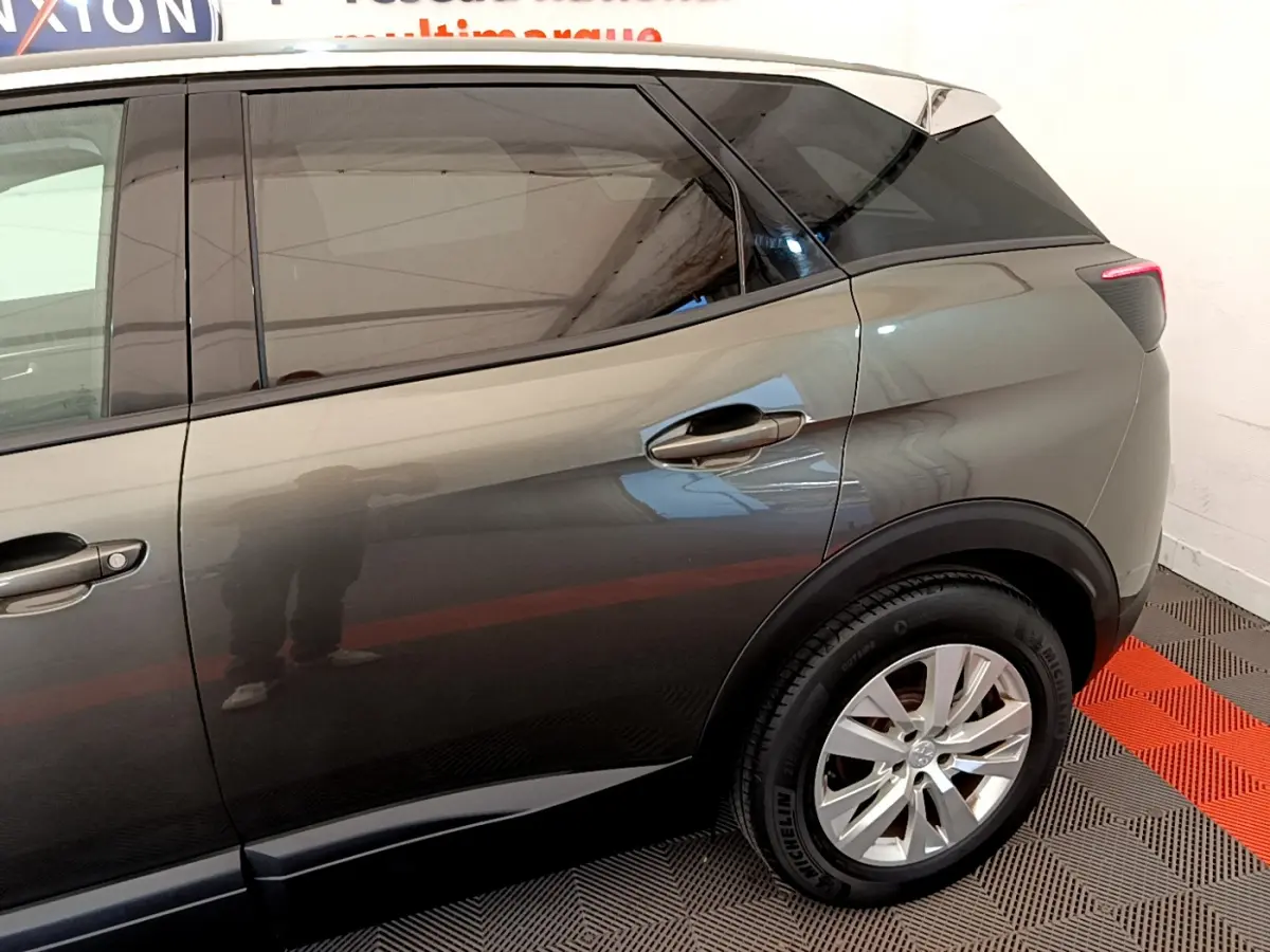 Vue latérale côté droit du Peugeot 3008 gris foncé, mettant en valeur la porte arrière et la roue arrière.