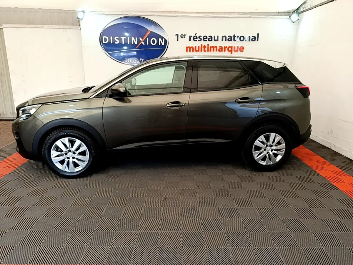 Vue latérale droite d'un Peugeot 3008 gris foncé de 2020, finition Puretech 130 S&S ACTIVE, en intérieur showroom.