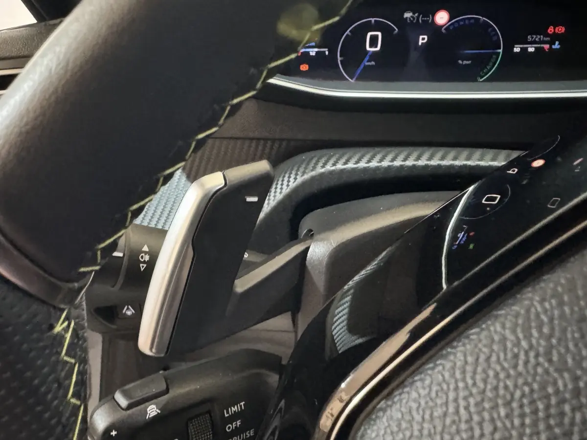 Gros plan sur le volant cuir et le combiné numérique de la Peugeot 208 Hybrid 136 eDCS6 GT, affichage multifonctions lumineux.