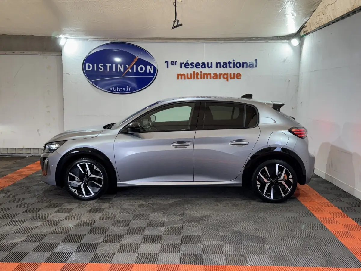 Vue de profil côté gauche d'une Peugeot 208 Hybrid 136 eDCS6 GT gris clair avec jantes noires et détails chromés.