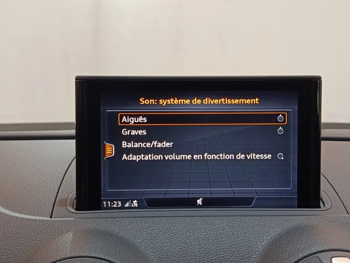 Écran tactile central affichant les réglages audio dans l’habitacle d’une Audi A3 blanche, vue de face.
