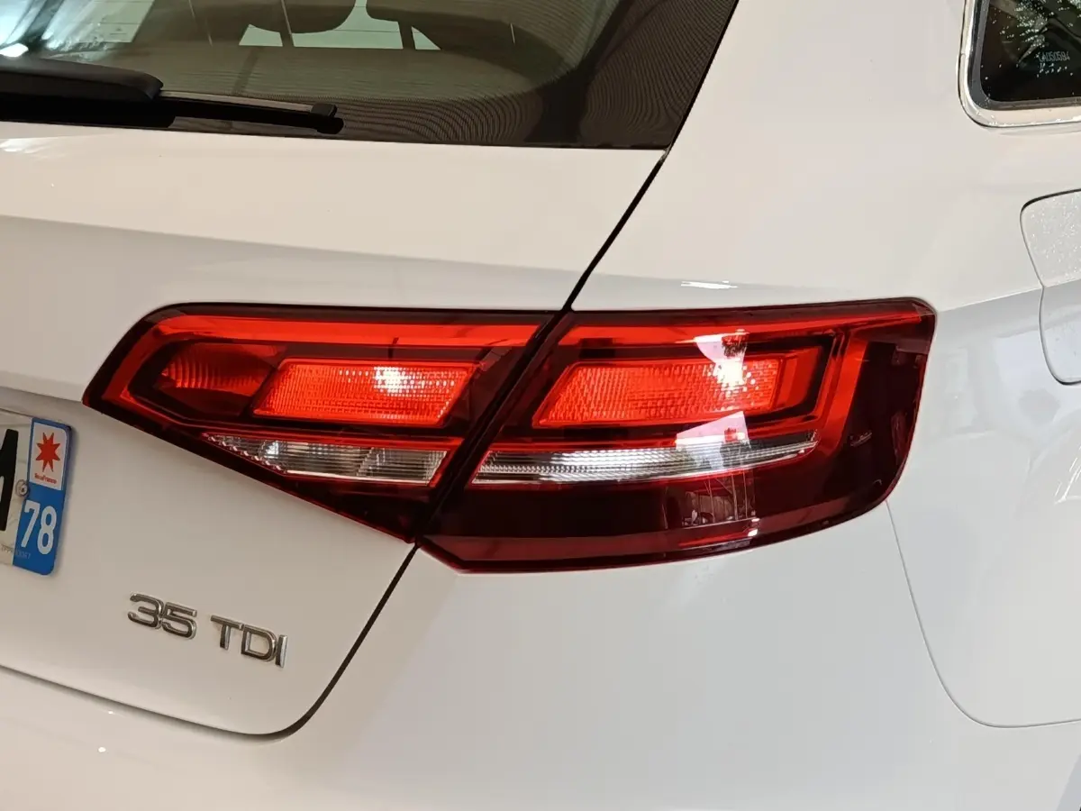 Gros plan sur le feu arrière droit d’une Audi A3 35 TDI blanche, avec logo de motorisation visible sur la malle.