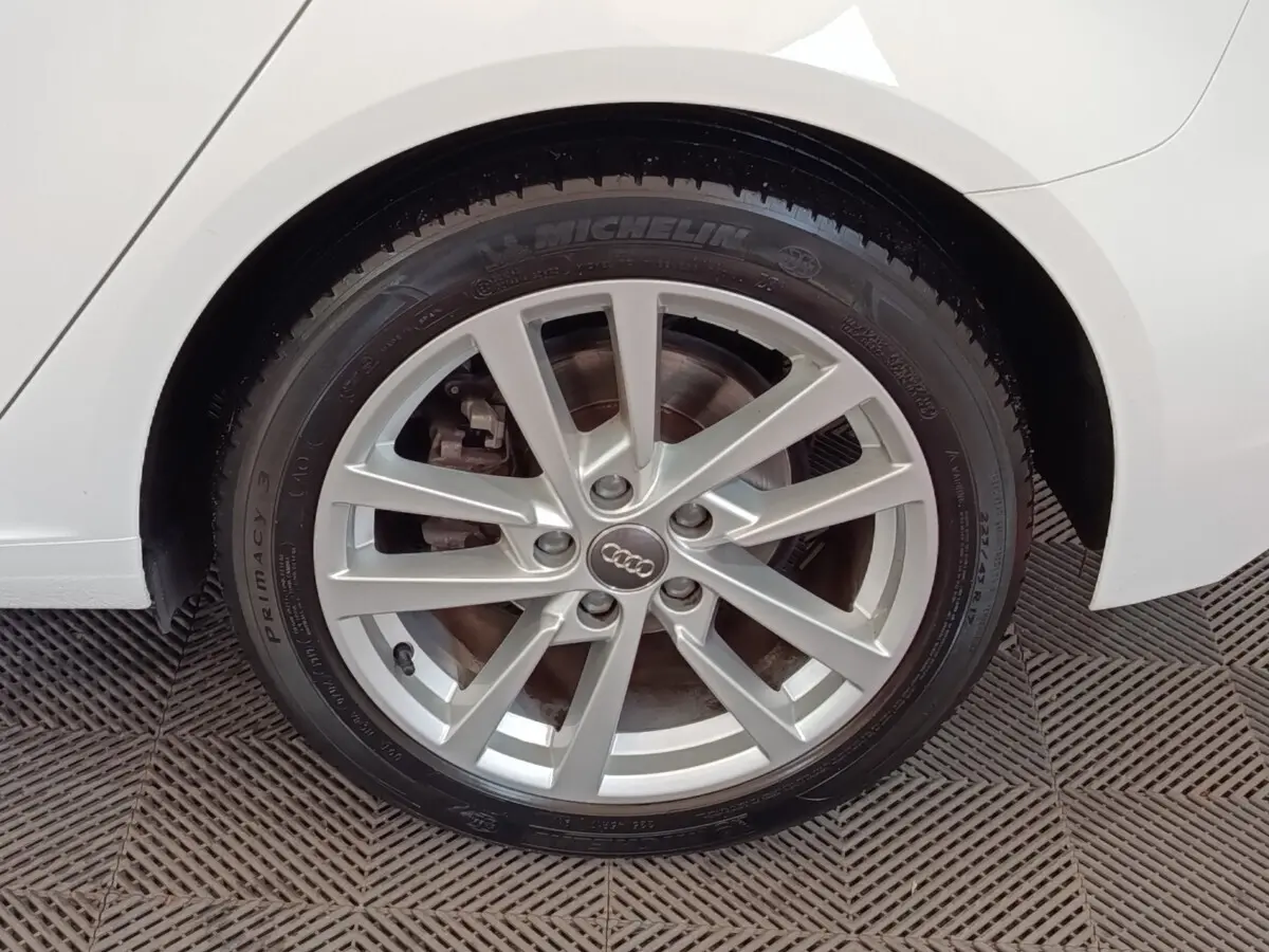 Gros plan sur la roue arrière droite d'une Audi A3 blanche, avec jante alliage argentée et pneu Michelin.
