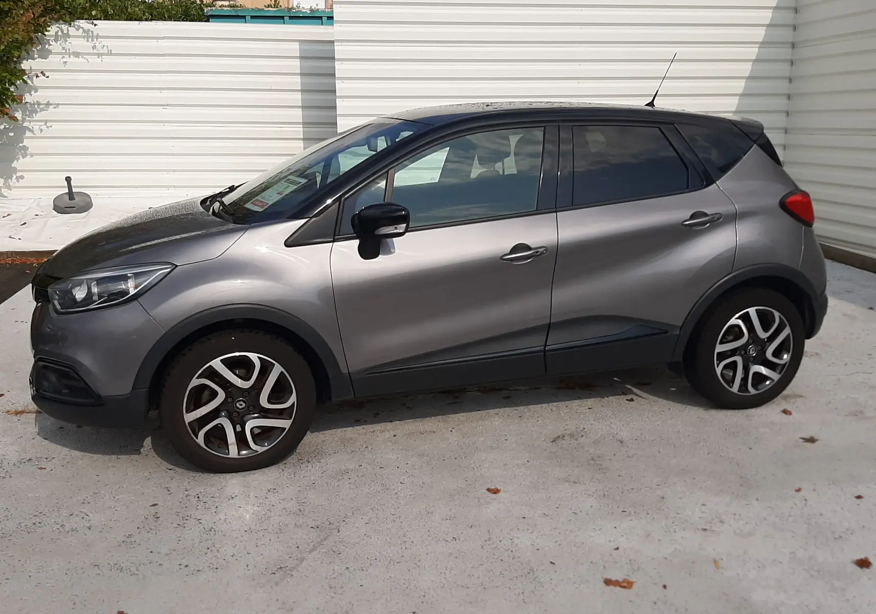 Renault Captur gris Cassiopée avec toit noir, vue de profil côté gauche, roues alliage 17 pouces biton.