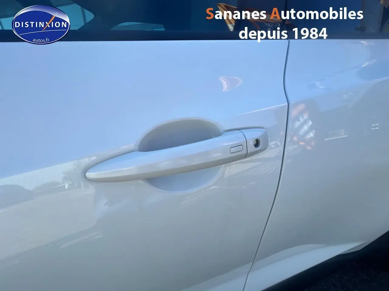 Poignée de porte côté droit blanc nacré du Nissan Juke 2024, finition N-Connecta avec coques de rétroviseurs noires.