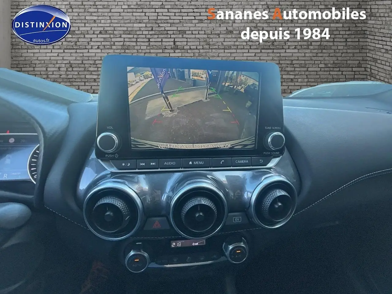 Vue intérieure centrée sur l’écran tactile affichant la caméra de recul du Nissan Juke blanc 2024.