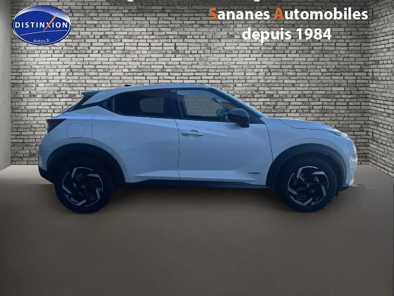 Vue de profil côté gauche du Nissan Juke blanc 2024 avec coques de rétroviseurs noires et vitres teintées.