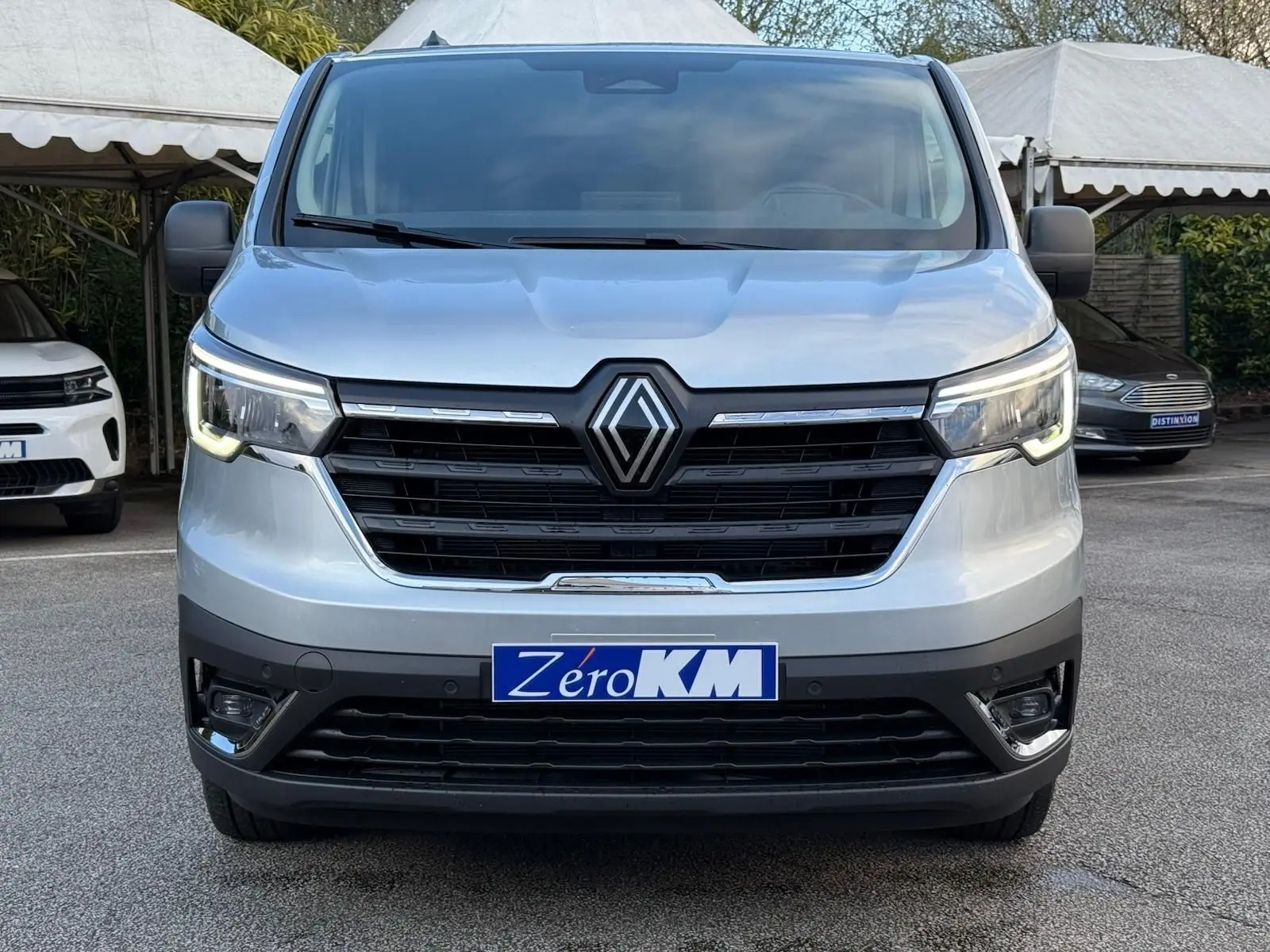 Vue rapprochée du volant noir et du tableau de bord du Renault Trafic cabine approfondie gris Highland, avec levier de vitesses manuel visible.