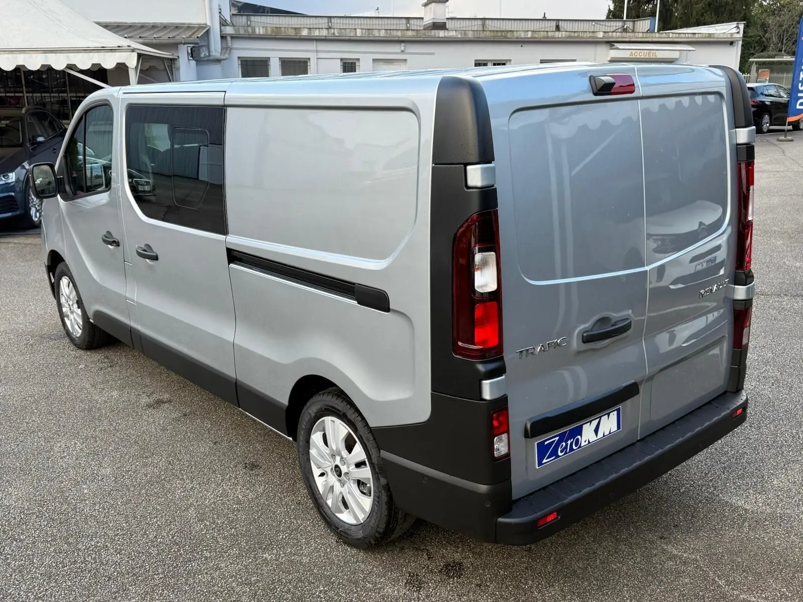 Vue 3/4 avant droit d’un Renault Trafic cabine approfondie gris Highland avec jantes alliage et calandre noire.