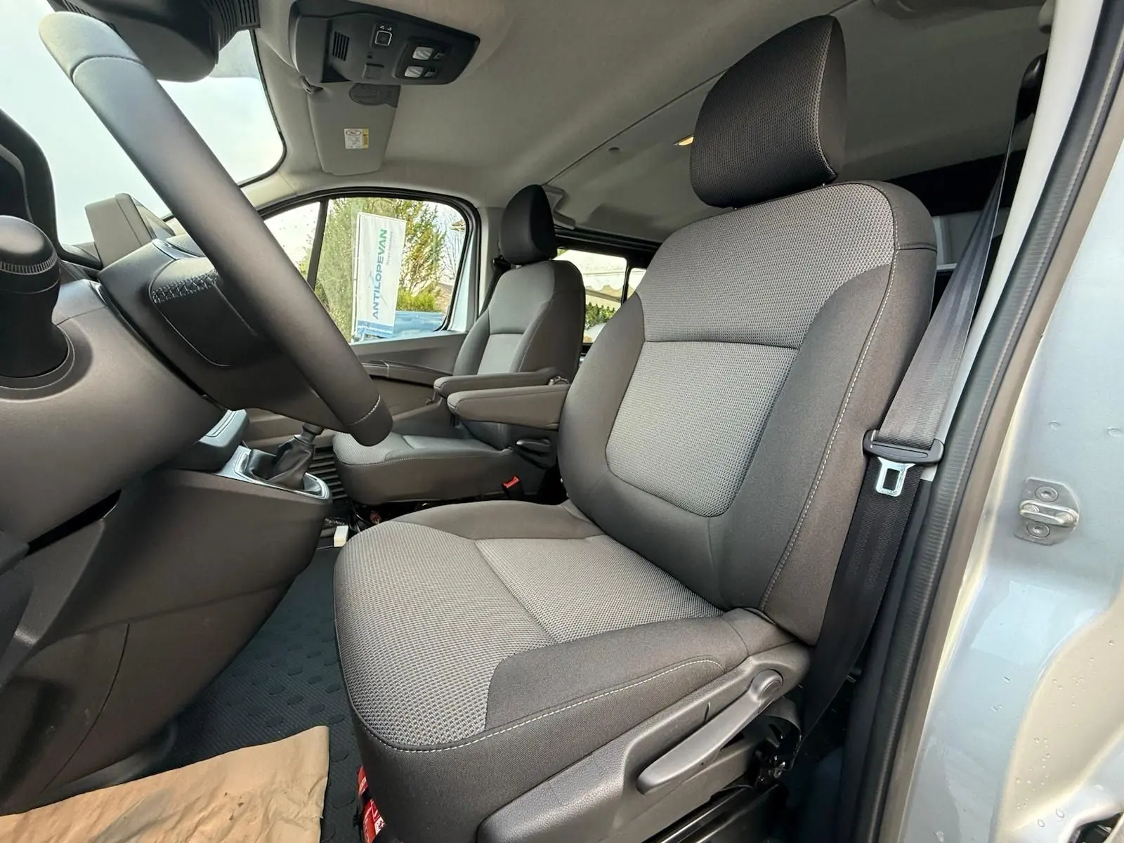 Vue 3/4 arrière droite du Renault Trafic cabine approfondie gris Highland avec hayon arrière et jantes alliage.