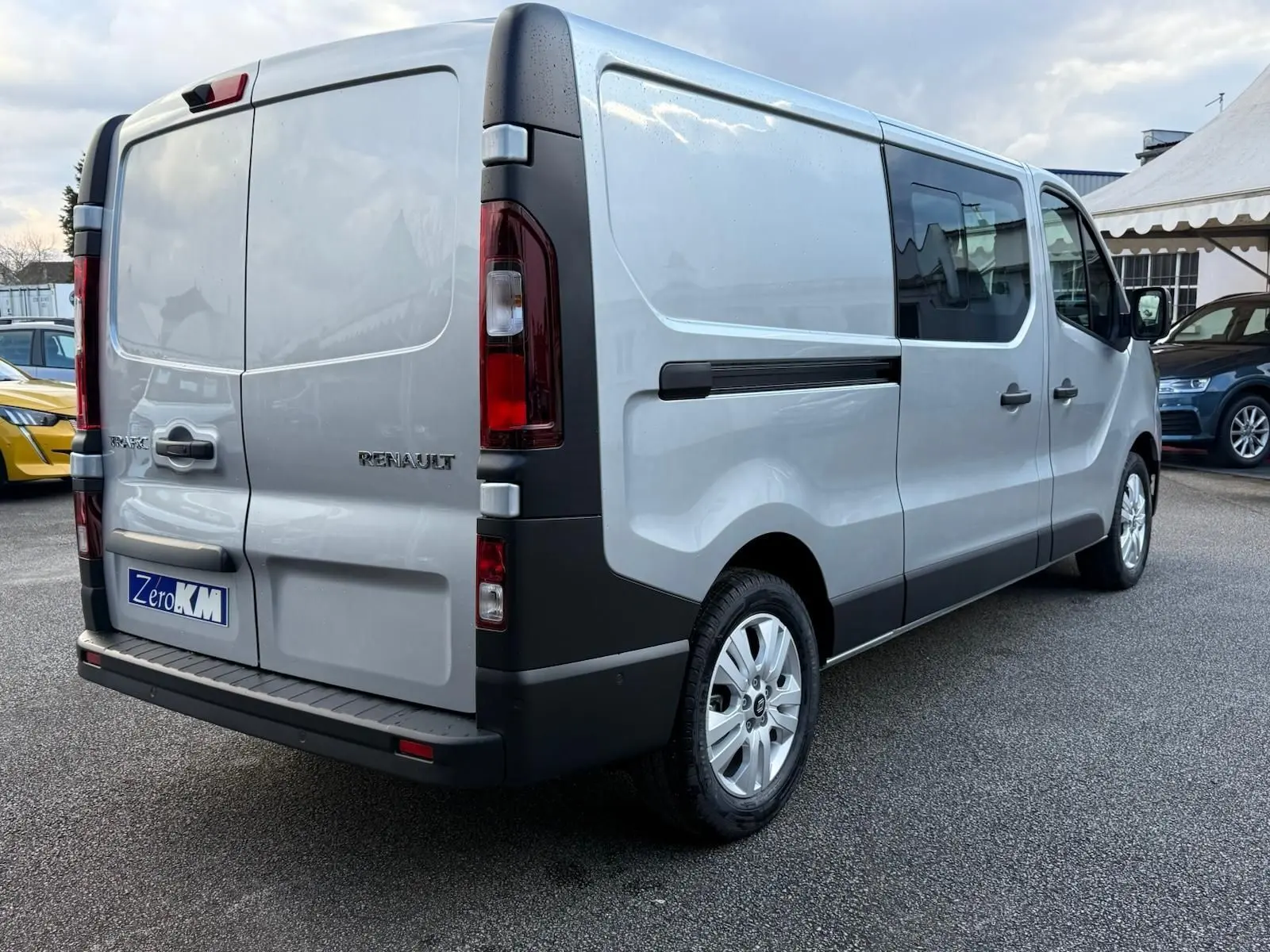 Vue 3/4 avant droite d'un Renault Trafic cabine approfondie gris Highland avec calandre noire et jantes alliage.