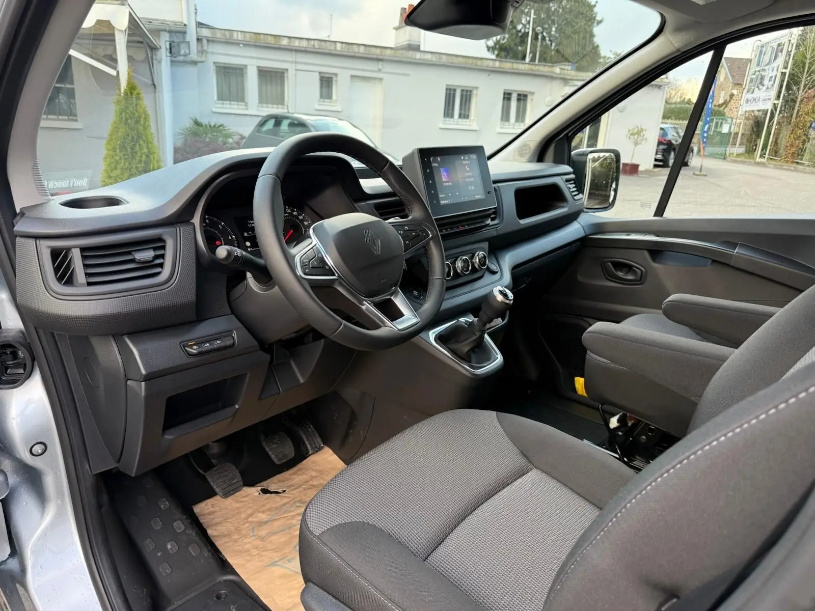 Renault Trafic cabine approfondie gris Highland vu en 3/4 avant droit, avec calandre noire et feux LED modernes.