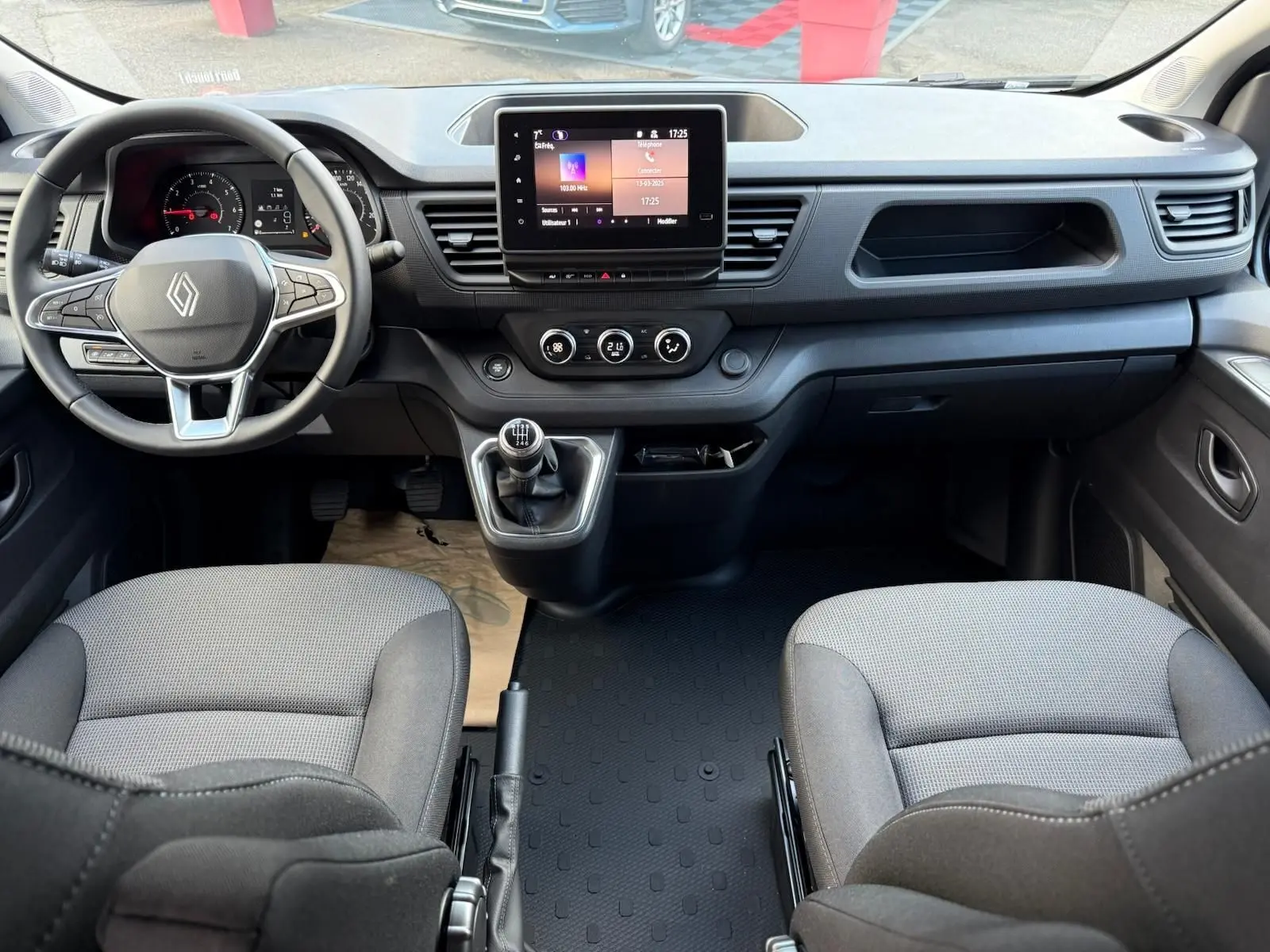 Vue 3/4 avant d’un Renault Trafic cabine approfondie gris Highland 2025 avec calandre noire et feux LED distinctifs.