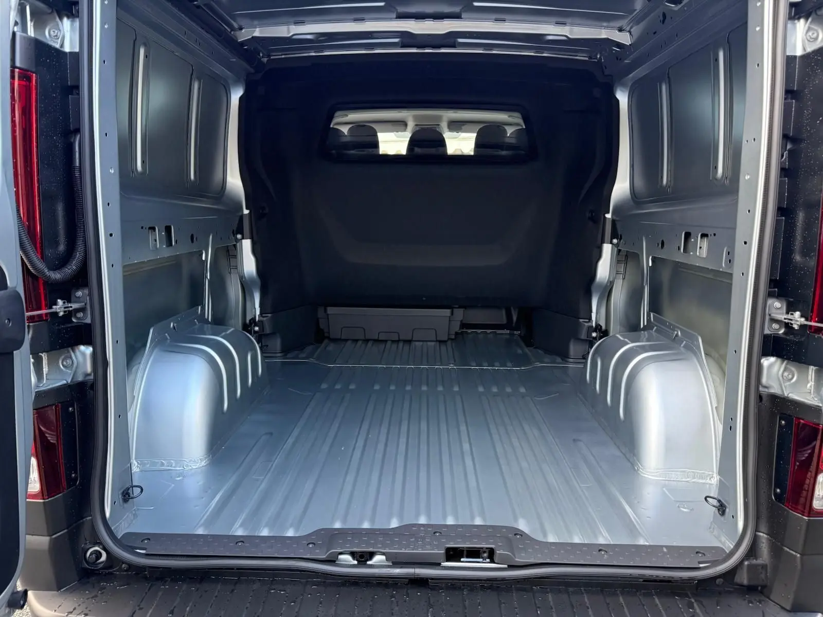 Intérieur avant du Renault Trafic cabine approfondie 2025, vue du poste de conduite avec tableau de bord et sièges gris.