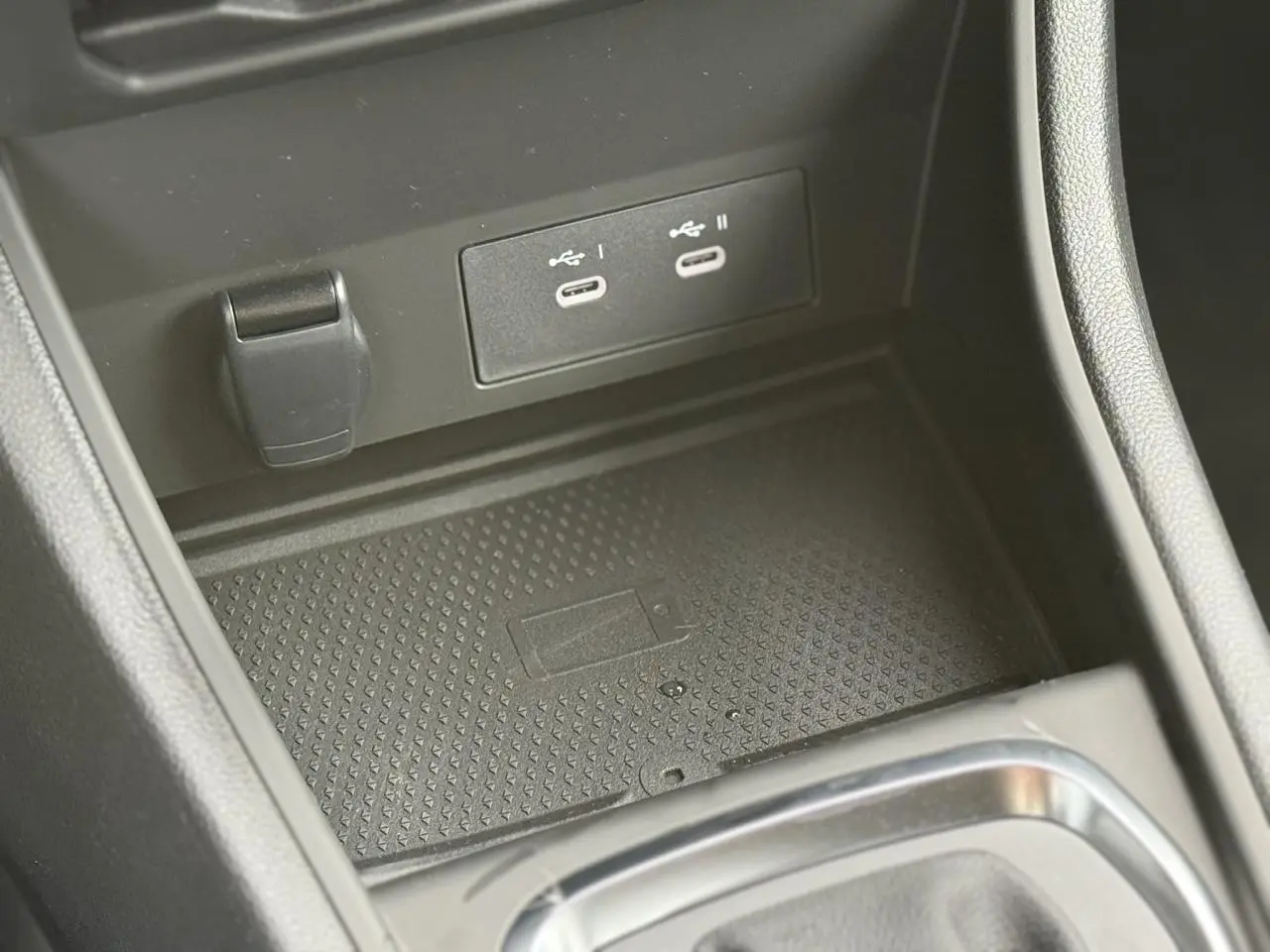 Gros plan sur la console centrale noire du Renault Captur avec deux ports USB-C et un espace de charge sans fil.