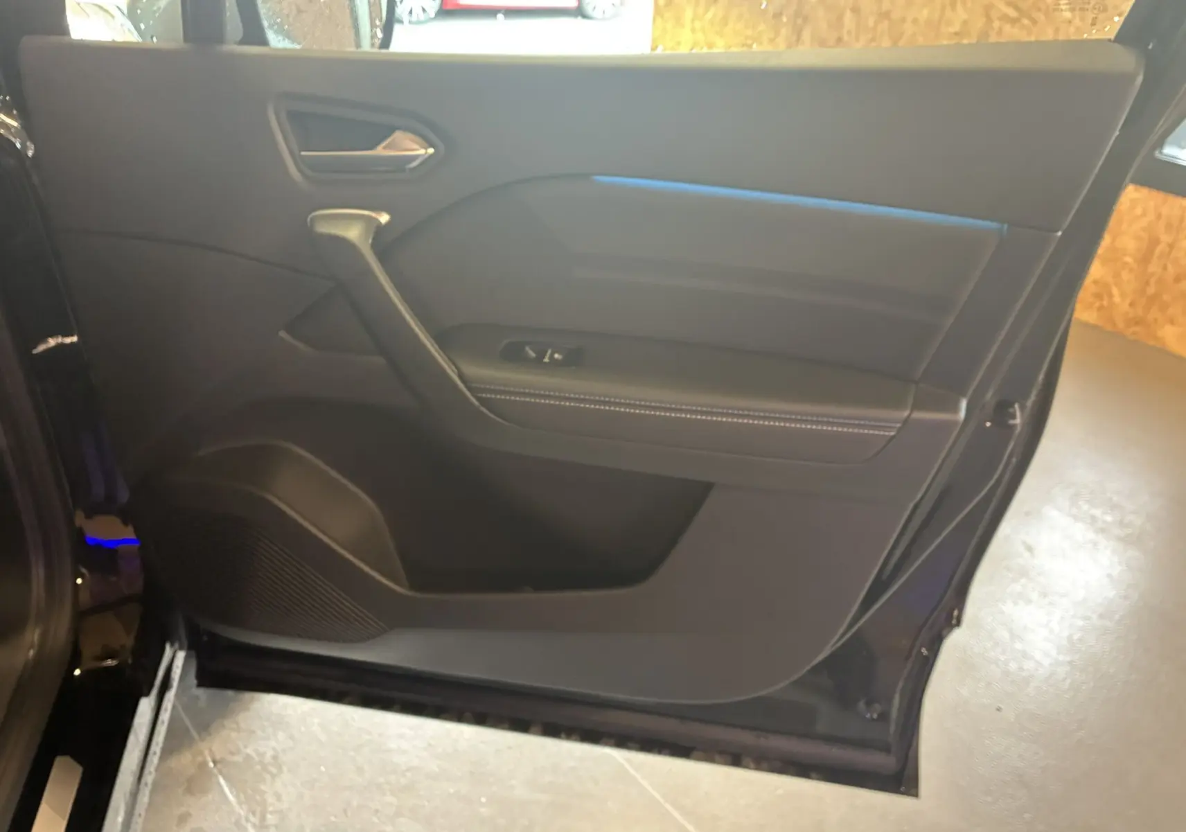 Porte intérieure côté gauche du Renault Captur E-Tech 2025, finition noire avec surpiqûres blanches et poignée intégrée.