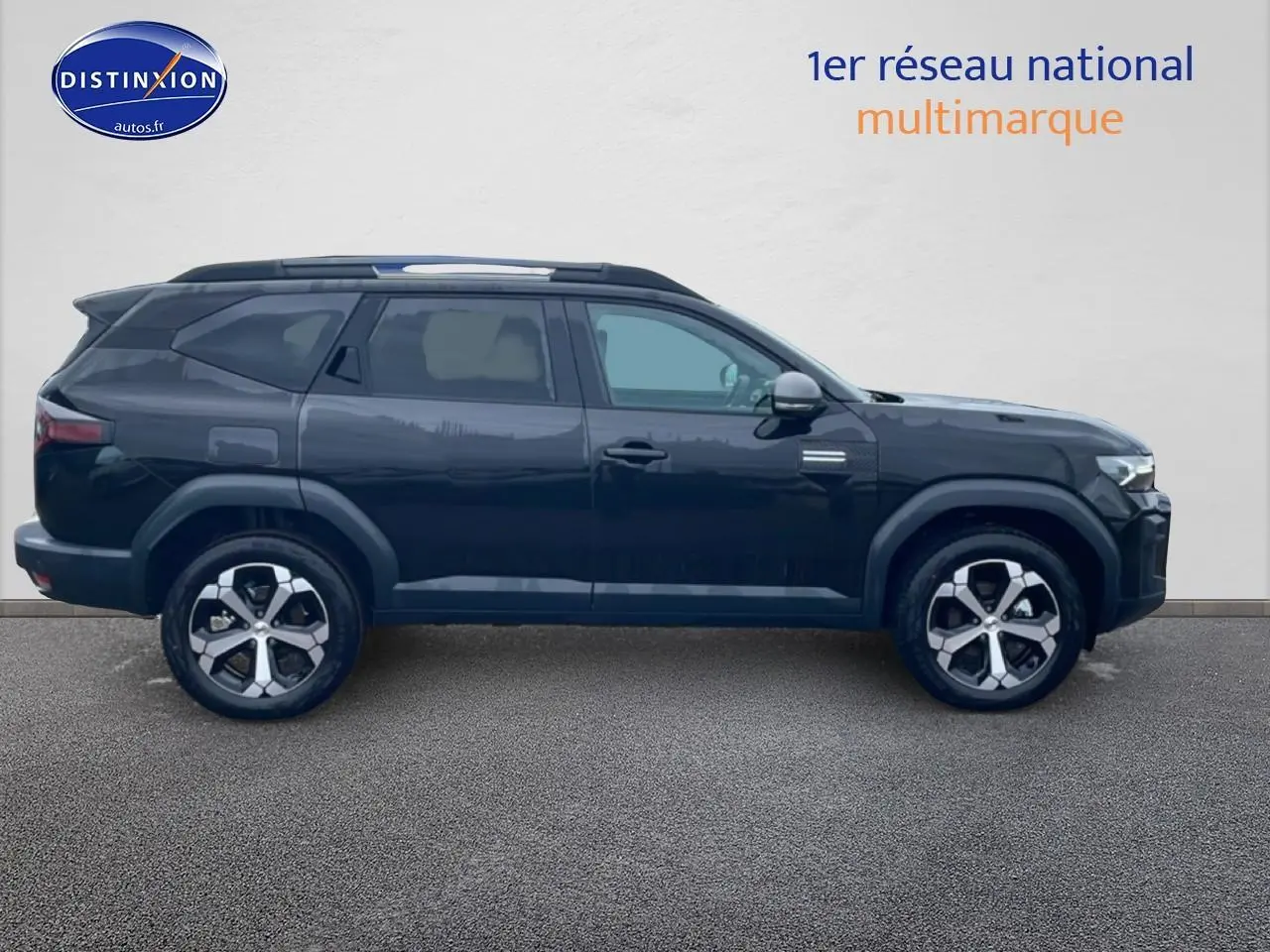 Profil droit du SUV Dacia Bigster noir 2025 avec jantes alliage 18 pouces et barres de toit.