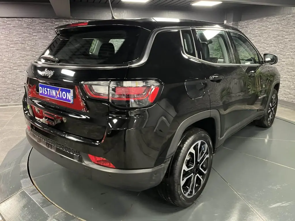 Vue 3/4 arrière droite du Jeep Compass noir 2024 avec jantes alliage 18 pouces et feux arrière LED distinctifs.