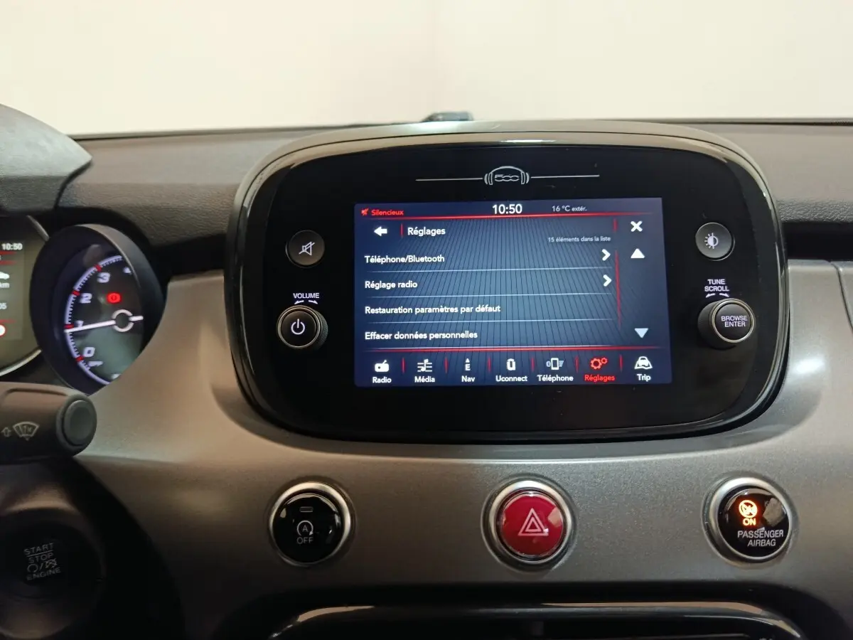 Vue rapprochée du tableau de bord de la Fiat 500X 2021, écran tactile central allumé avec menu réglages visible.