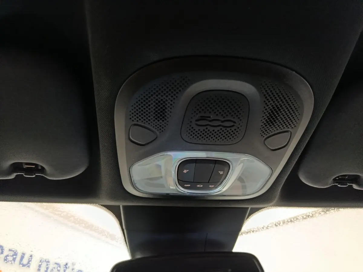 Vue intérieure du plafonnier noir avec commandes d’éclairage et haut-parleur marqué du logo 500 sur Fiat 500X.