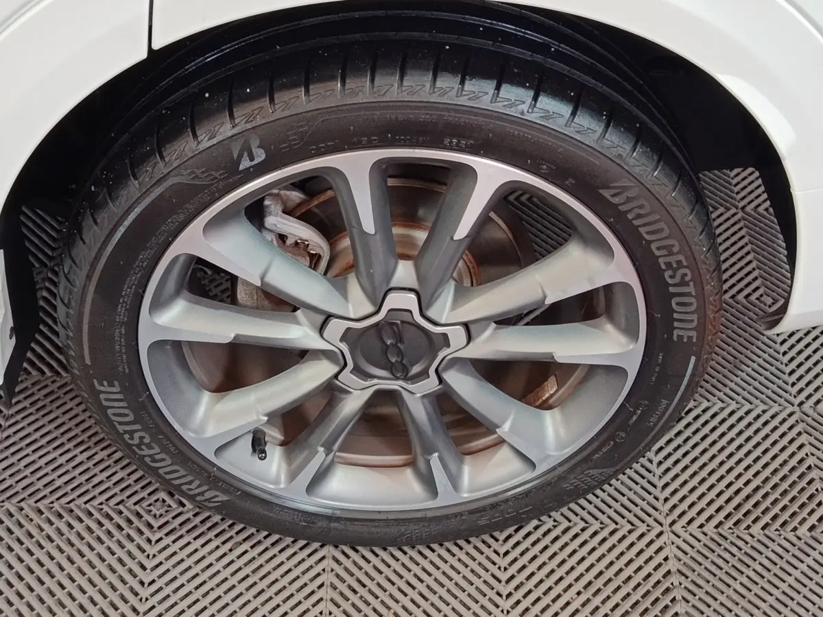 Gros plan sur la roue avant droite argentée du FIAT 500X noir, avec pneu Bridgestone et jante à multiples branches.