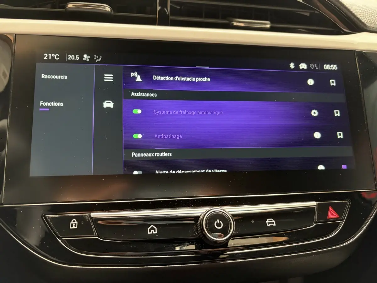 Vue rapprochée de l'écran tactile central de l'Opel Corsa 2025 gris clair affichant les assistances à la conduite activées.