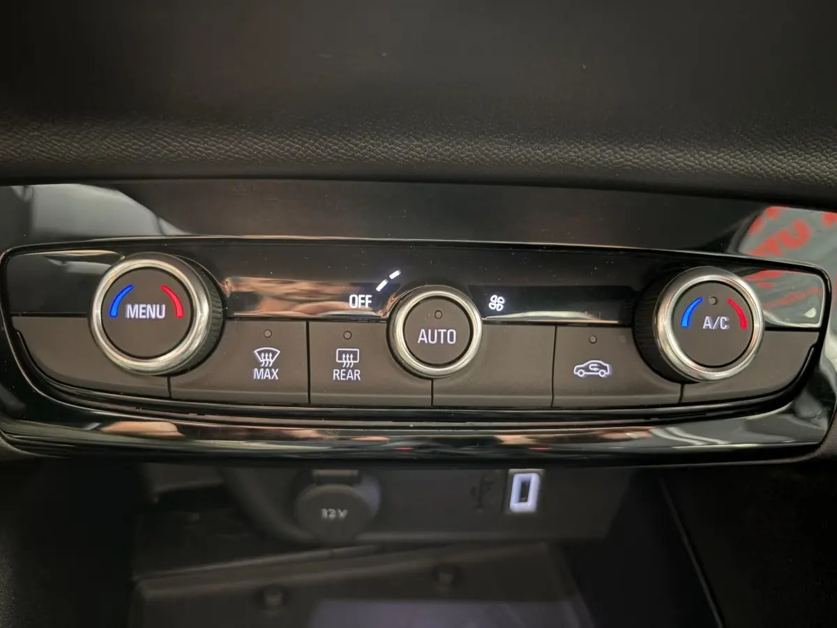 Gros plan sur la commande de climatisation automatique de la Opel Corsa gris clair, avec réglages température et ventilation.