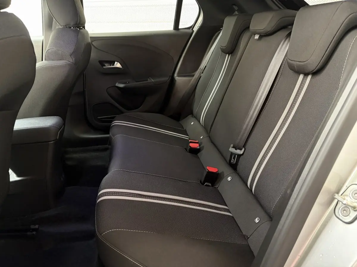 Vue intérieure côté droit montrant la banquette arrière noire avec surpiqûres claires de l'Opel Corsa 2025.