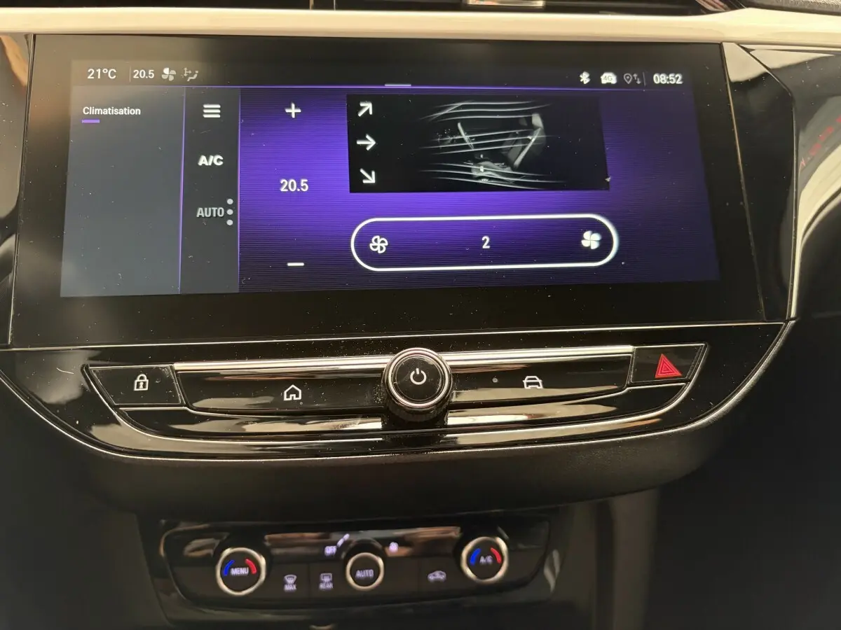 Vue rapprochée de l'écran tactile central et des commandes de climatisation d'une Opel Corsa gris clair, version 2025.