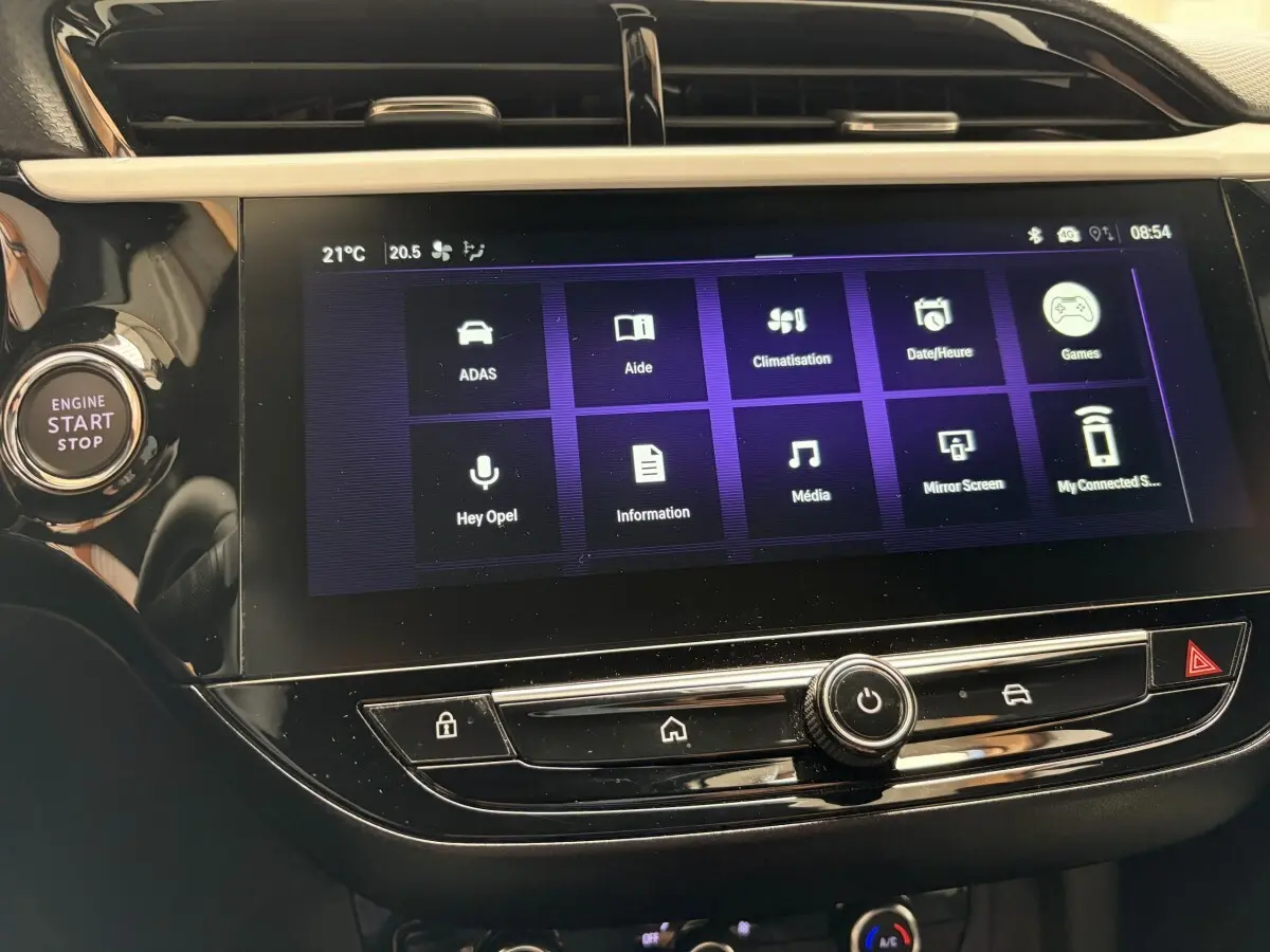 Gros plan sur l’écran tactile central et bouton start/stop dans l’habitacle noir de l’Opel Corsa 2025.