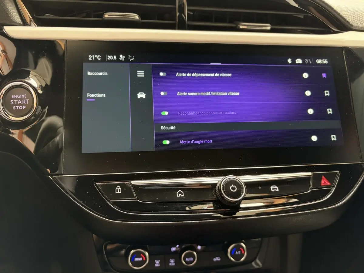 Vue rapprochée de l'écran tactile central noir de l'Opel Corsa 2025 avec menu de sécurité affiché et bouton start/stop à gauche.