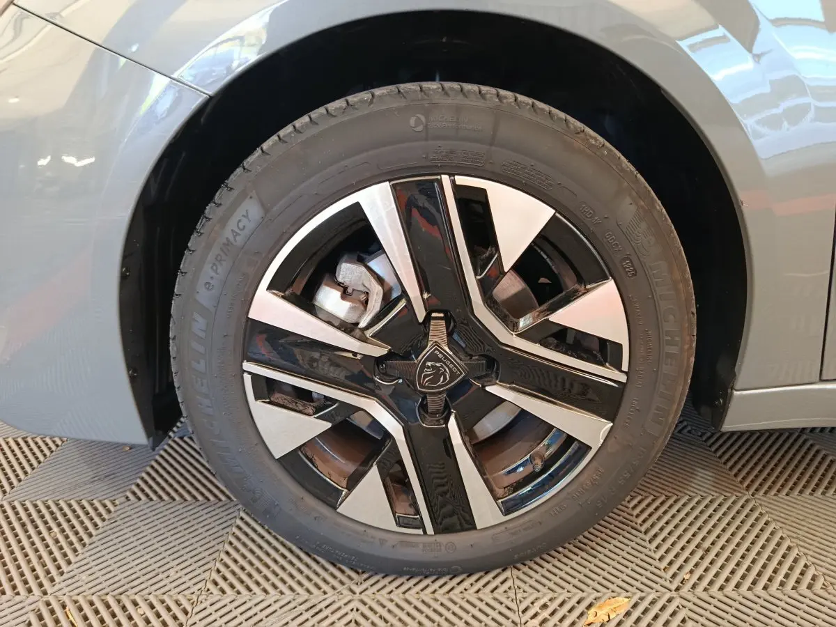 Gros plan sur la roue avant gauche de la Peugeot 208 gris foncé avec jante alliage noire et argentée distinctive.