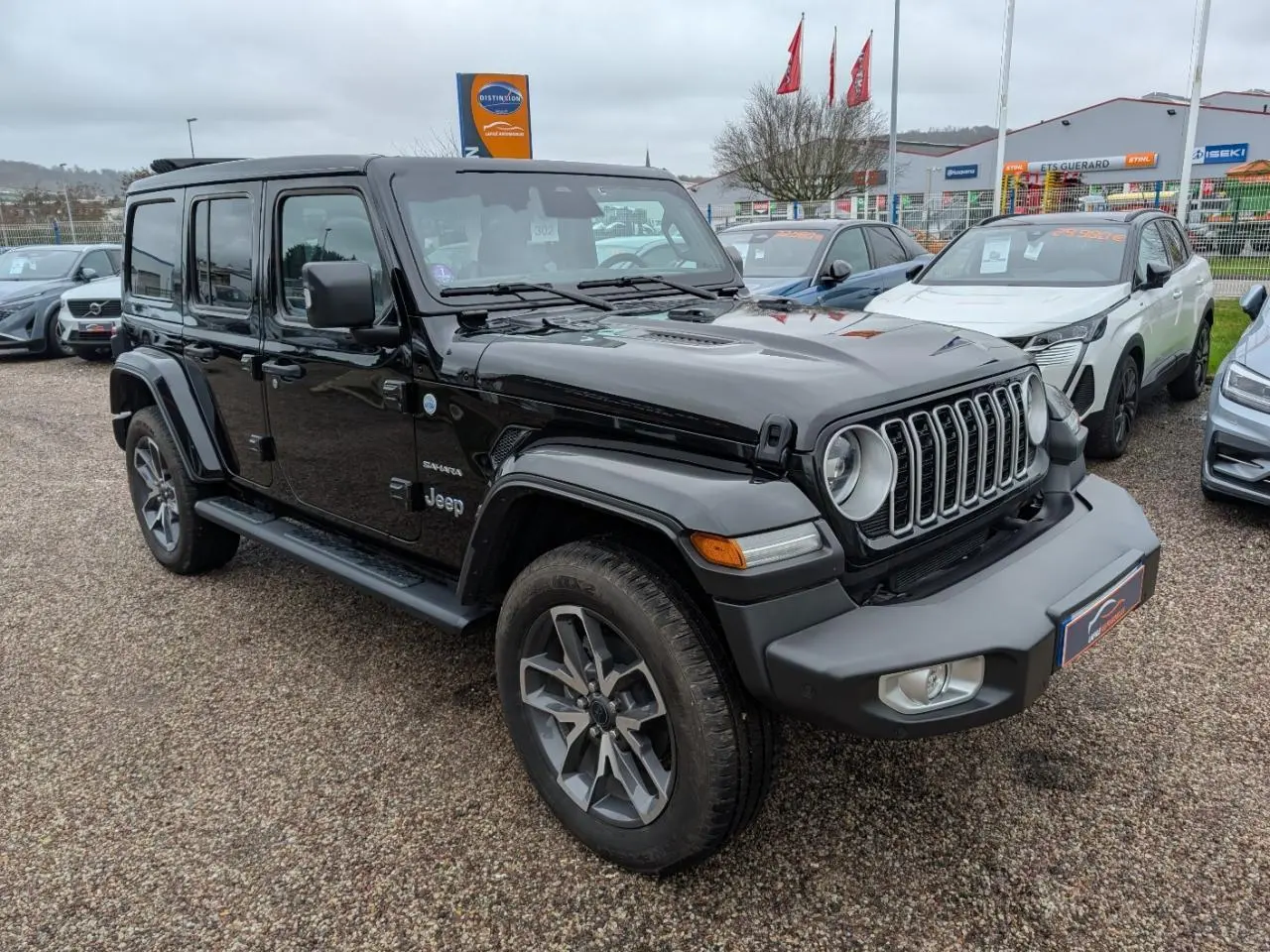 Jeep Wrangler 2024 noir en 3/4 avant droit avec jantes alliage 20 pouces et marchepieds visibles.