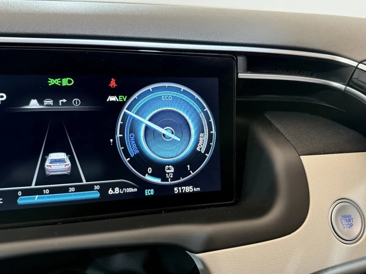 Gros plan sur l'écran digital du tableau de bord du Hyundai Tucson gris foncé avec bouton start/stop visible.