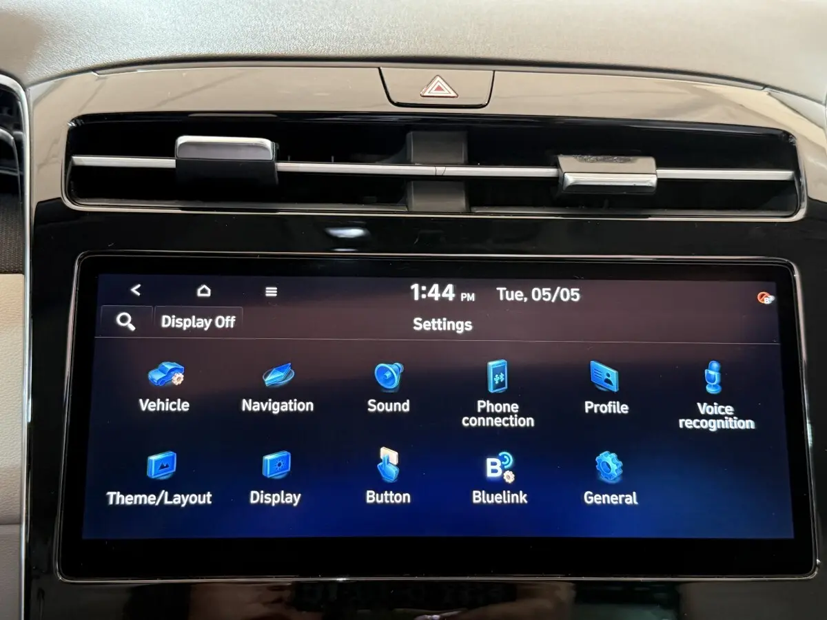 Gros plan sur l'écran tactile central du tableau de bord du Hyundai Tucson gris foncé, affichant le menu des réglages.