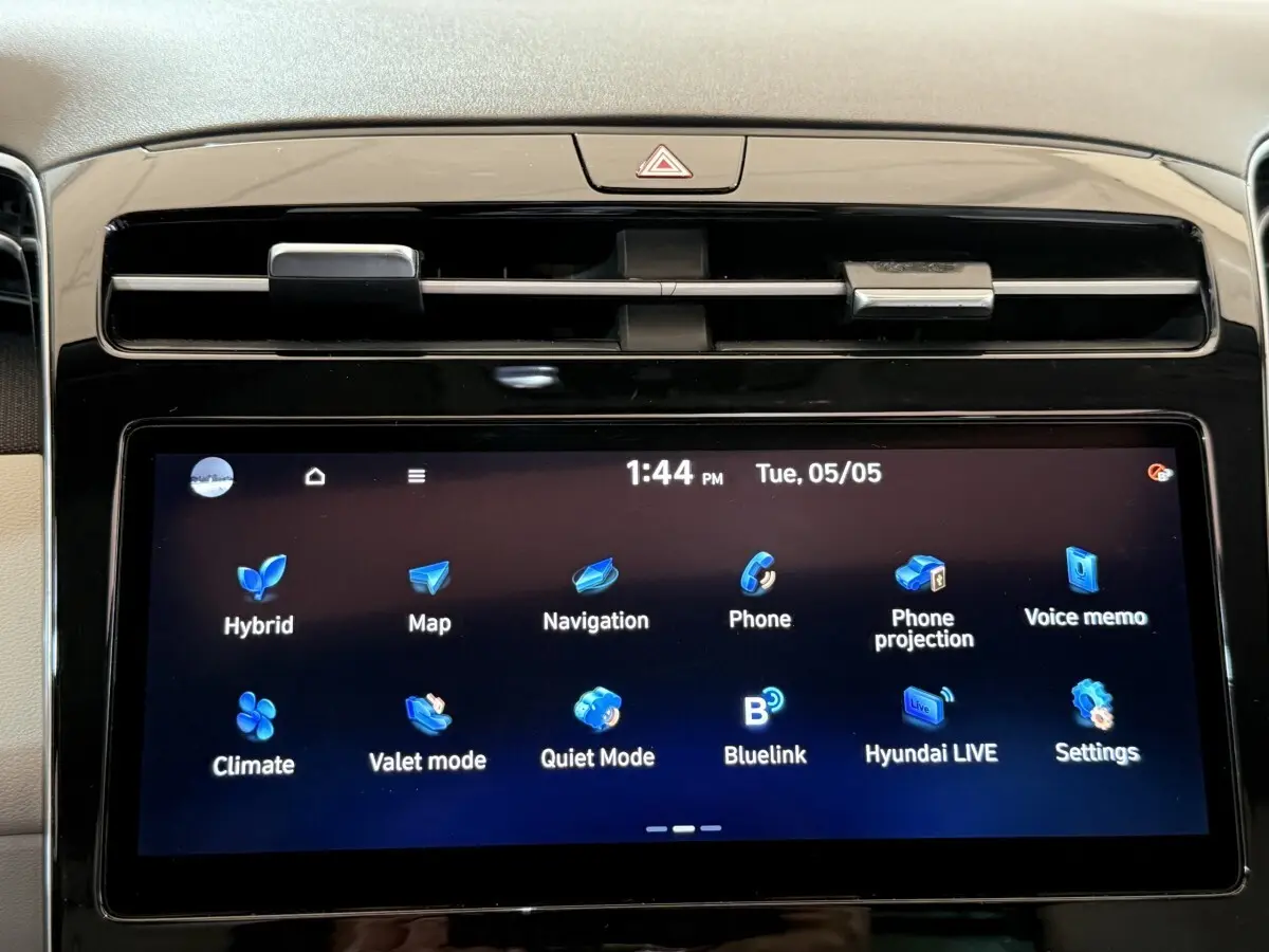 Gros plan sur l’écran tactile central du Hyundai Tucson gris foncé, affichant les options de navigation et connectivité.