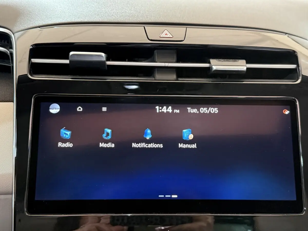 Écran tactile central du tableau de bord du Hyundai Tucson gris foncé, affichant les options radio, media et notifications.