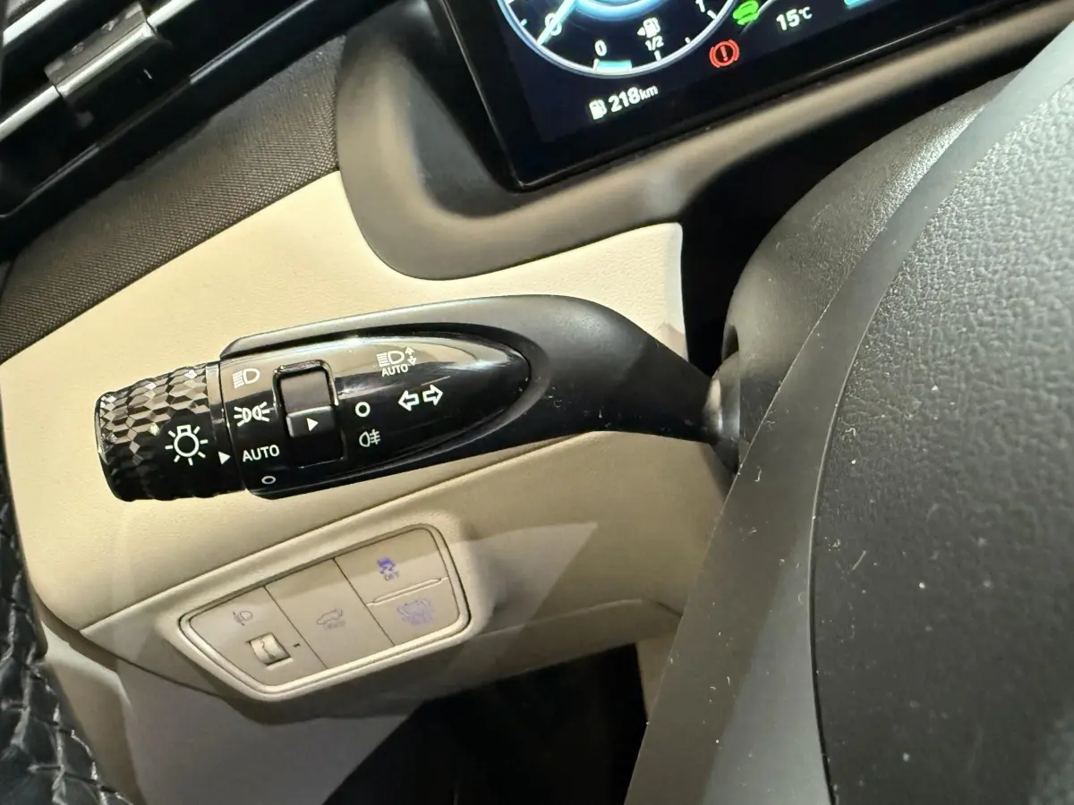 Gros plan sur la commande des phares et clignotants à gauche du volant du Hyundai Tucson gris foncé 1.6 Hybrid 230 Executive 2021.