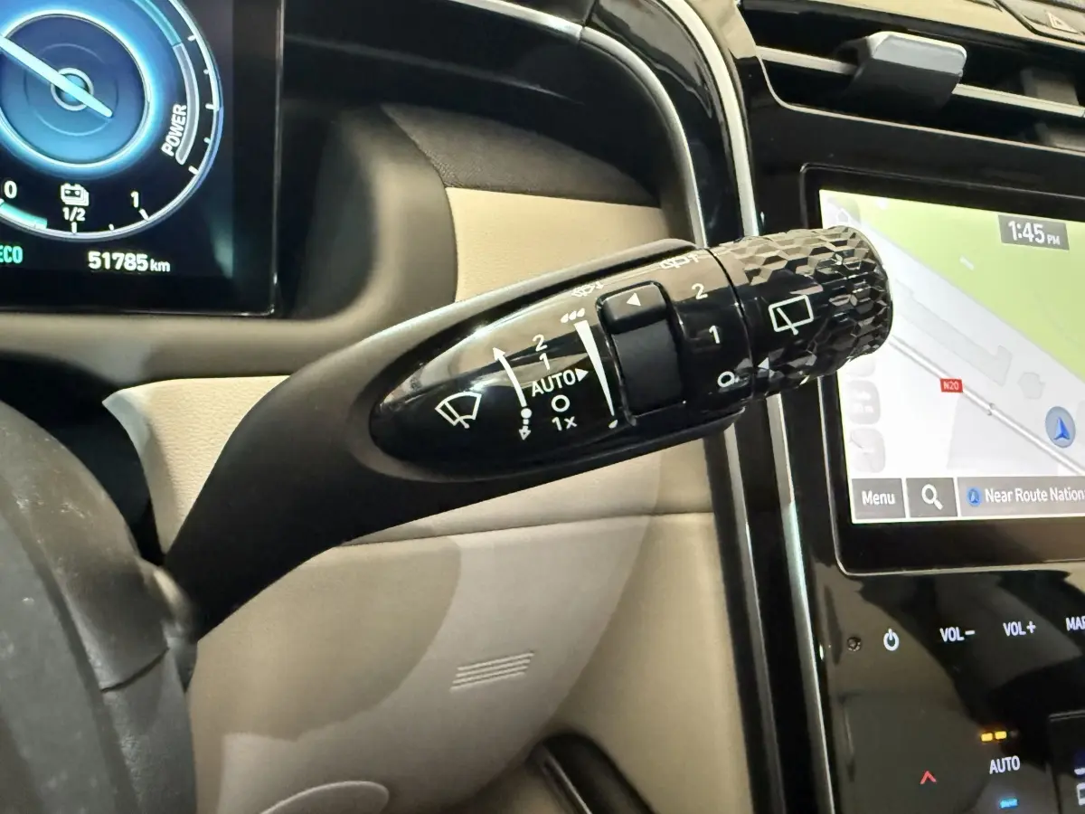 Gros plan sur la commande d’essuie-glace noire et l’écran tactile du tableau de bord du Hyundai Tucson gris foncé 2021.