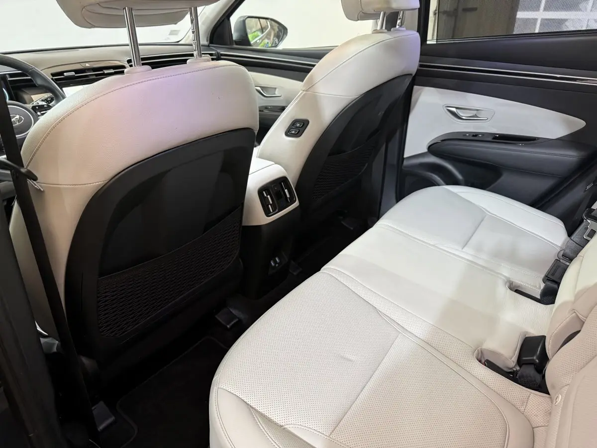 Vue intérieure arrière côté droit du Hyundai Tucson 1.6 Hybrid 230 Executive avec sièges cuir beige et finitions noires.