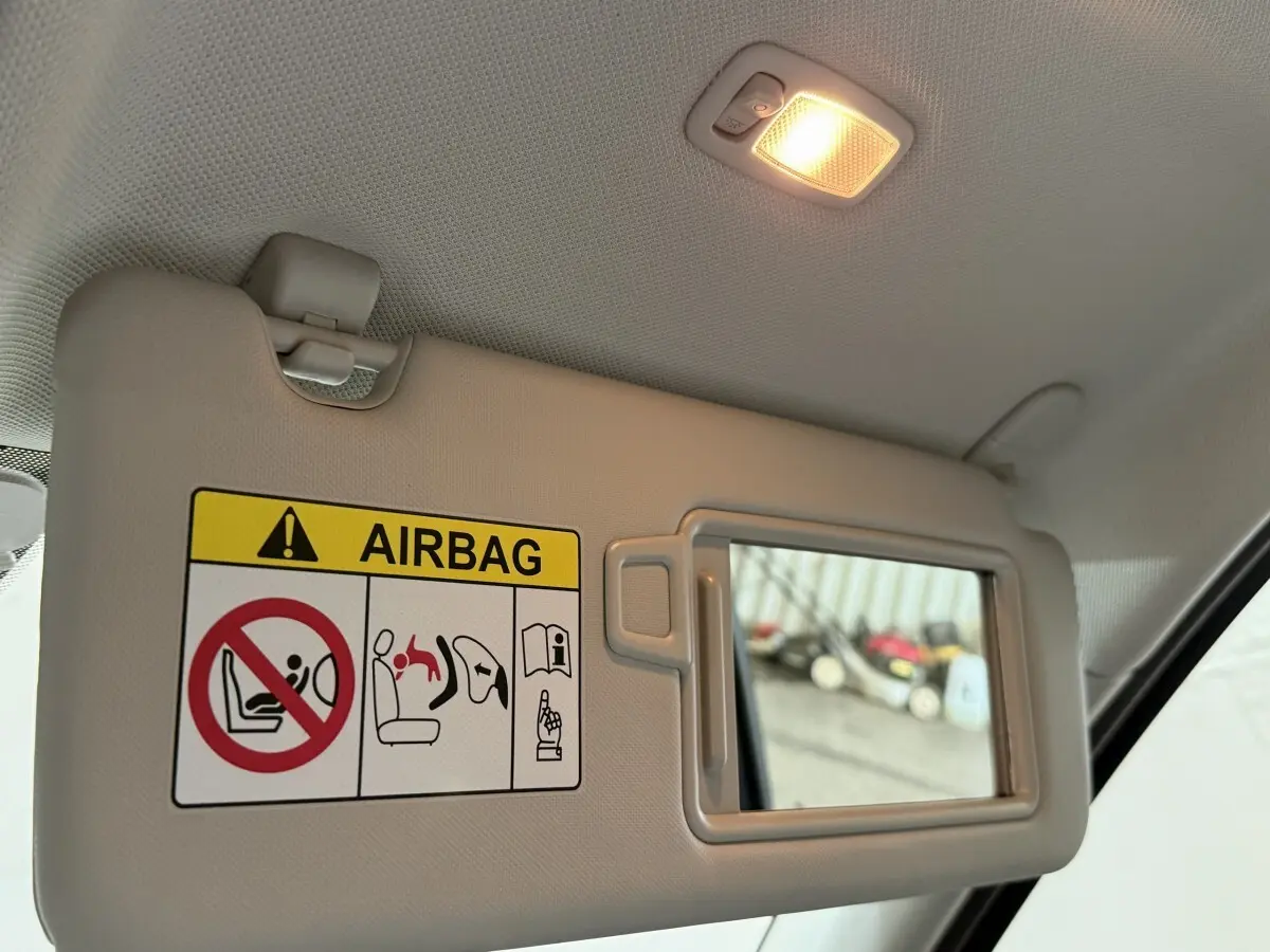 Détail du pare-soleil côté conducteur avec miroir et avertissement airbag dans l’habitacle gris clair du Hyundai Tucson 2021.