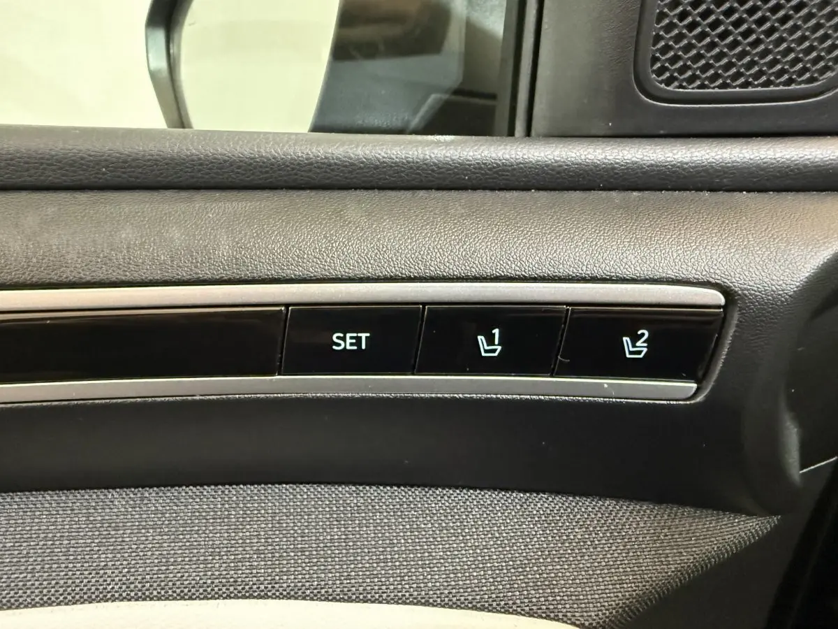 Détail des commandes de réglage mémoire des sièges sur la porte côté conducteur d’un Hyundai Tucson gris foncé.