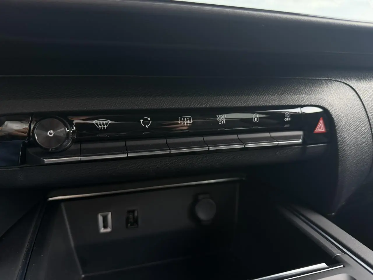 Gros plan sur la console centrale noire du Citroën C5 Aircross 2025 avec commandes climatisation et prises USB visibles.