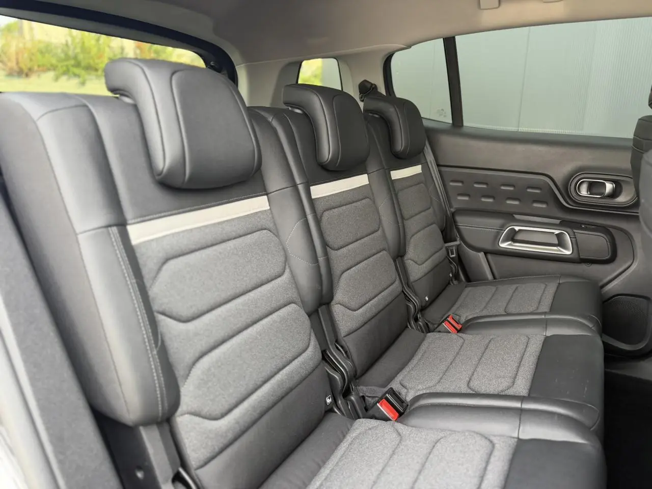 Vue latérale droite des trois sièges arrière indépendants gris foncé du Citroën C5 Aircross 2025 avec appuis-tête réglables.